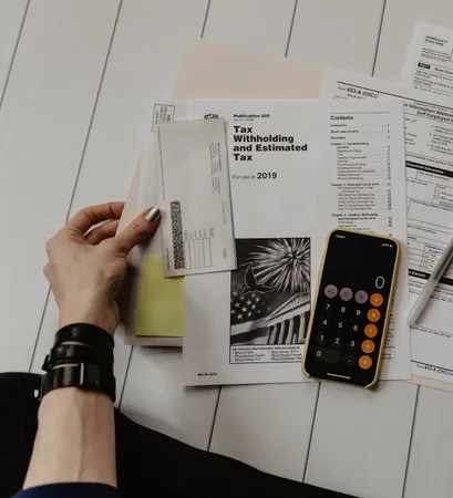 Hands organizing tax documents alongside a calculator during a tax planning session